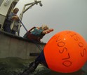 Diver's view of shipboard operations as scientist Rob Olson reaches to recover a float.